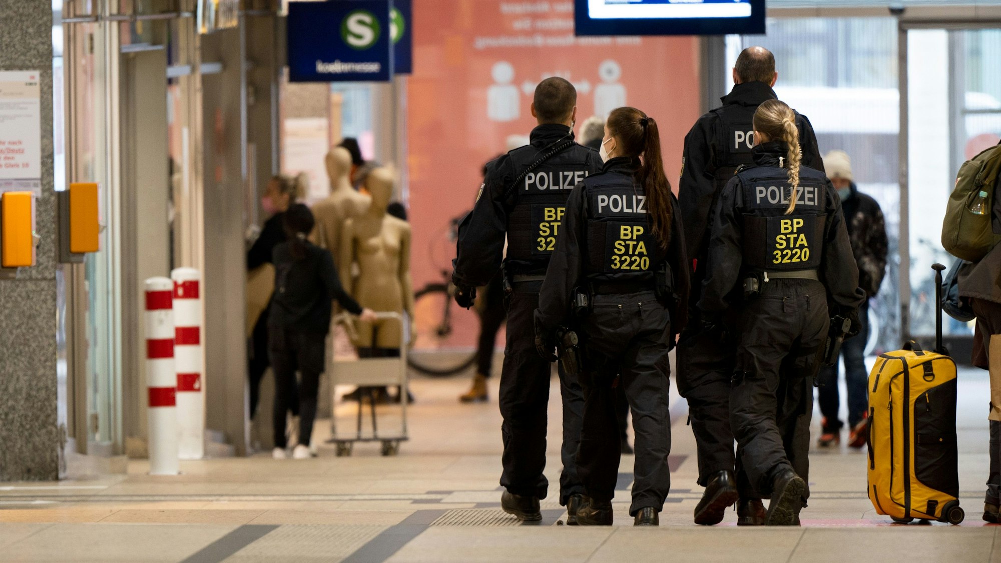 Frauen und Männer der Bundespolizei gehen durch den Hauptbahnhof in Köln.