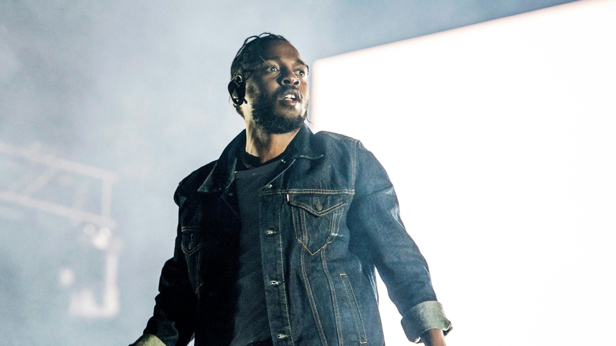 Kendrick Lamar mit Mikrofon auf einer Konzertbühne.