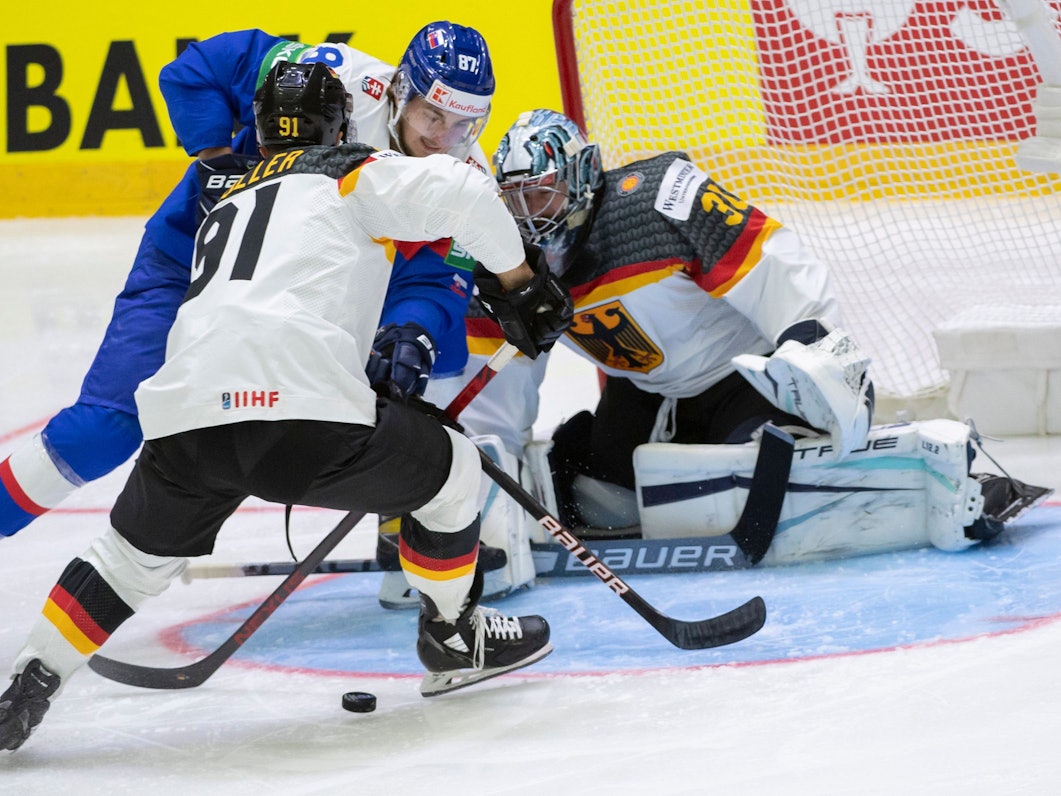 Pavol Regenda (M) aus der Slowakei, Verteidiger Moritz Müller (l) aus Deutschland und Torwart Philipp Grubauer (r) aus Deutschland in Aktion.