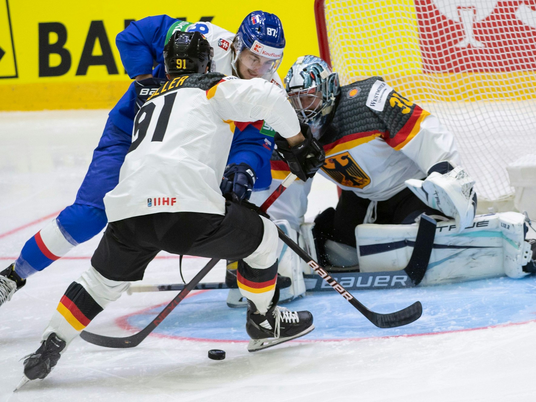 Pavol Regenda (M) aus der Slowakei, Verteidiger Moritz Müller (l) aus Deutschland und Torwart Philipp Grubauer (r) aus Deutschland in Aktion.