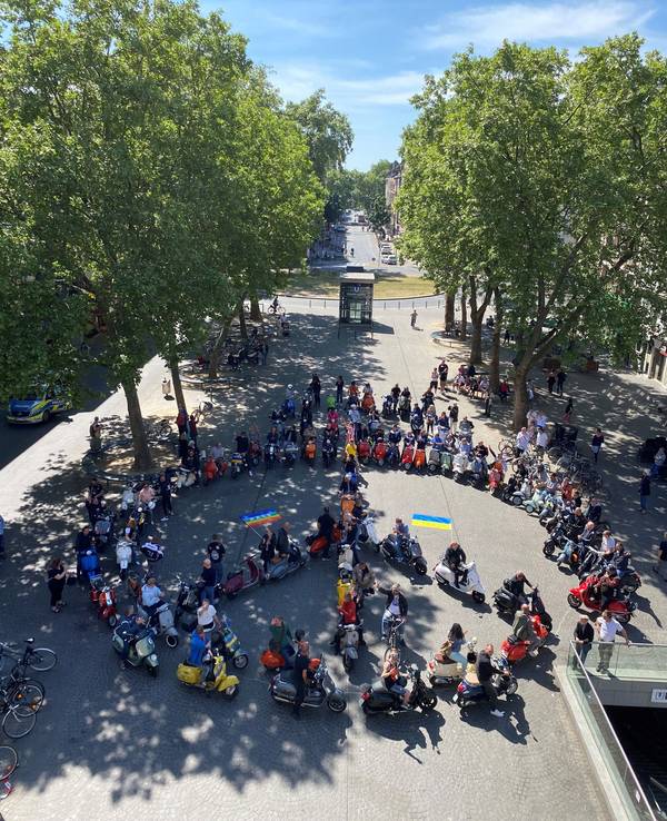80 Vespas formen auf dem Chlodwigplatz ein Peace-Zeichen.
