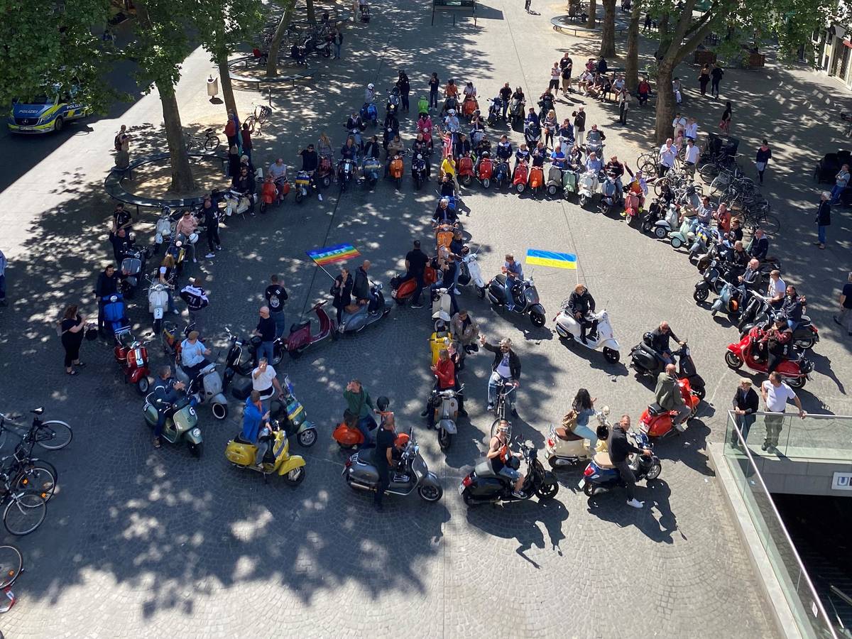 80 Vespas formen auf dem Chlodwigplatz ein Peace-Zeichen.