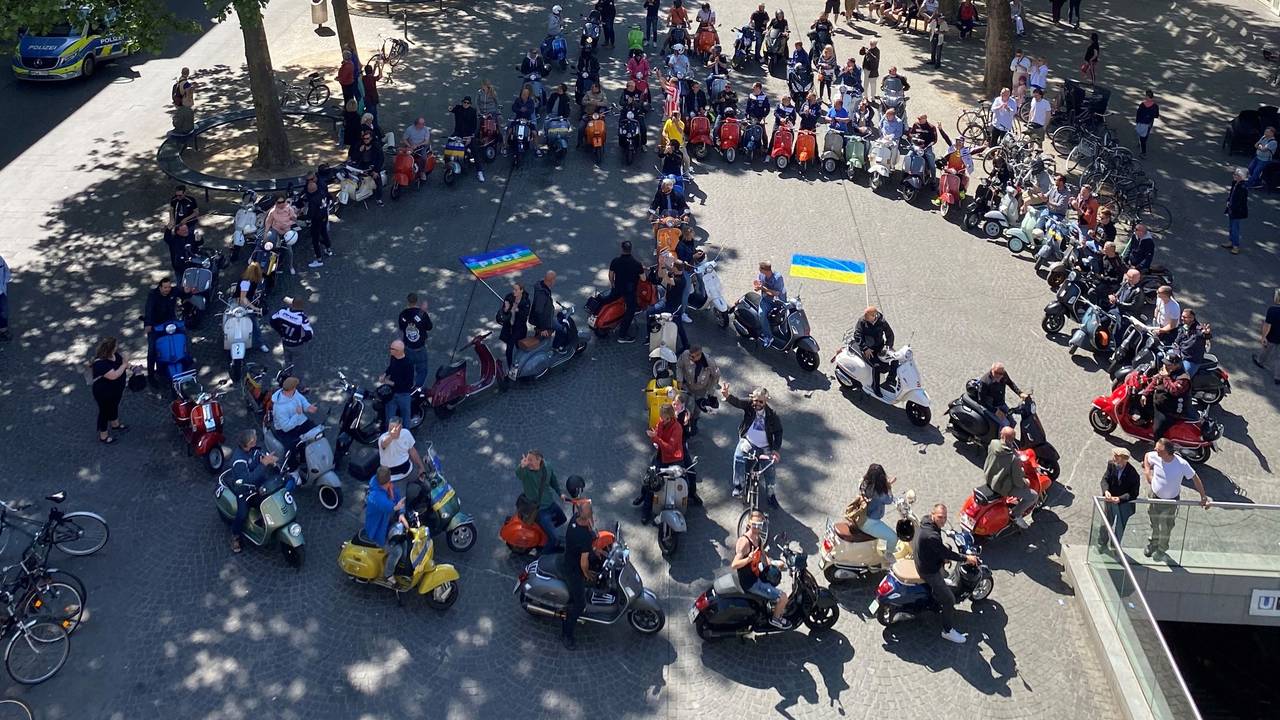 80 Vespas formen auf dem Chlodwigplatz ein Peace-Zeichen.
