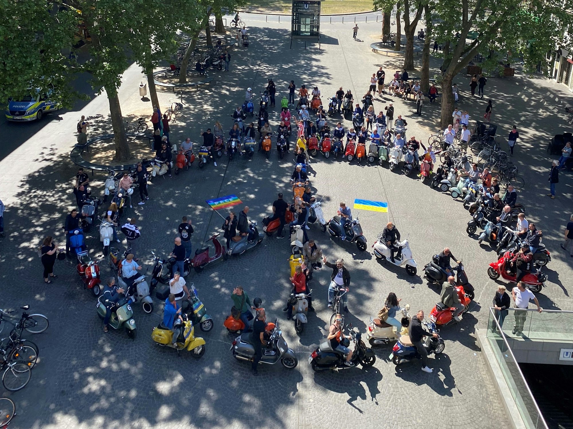 80 Vespas formen auf dem Chlodwigplatz ein Peace-Zeichen.