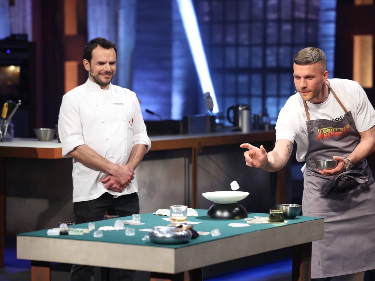 Lucas Podolski (r.) versucht, Eiswürfel in ein Whiskey-Glas zu werfen. Daneben steht Steffen Henssler (l.) in der Vox-Show „Grill den Henssler“ am 15. Mai 2022.
RTL/Frank Hempel
