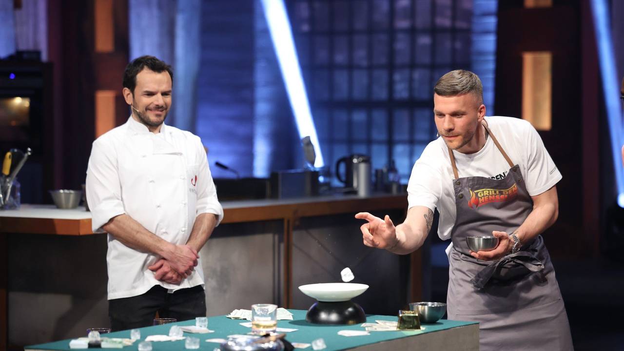 Lucas Podolski (r.) versucht, Eiswürfel in ein Whiskey-Glas zu werfen. Daneben steht Steffen Henssler (l.) in der Vox-Show „Grill den Henssler“ am 15. Mai 2022.
RTL/Frank Hempel