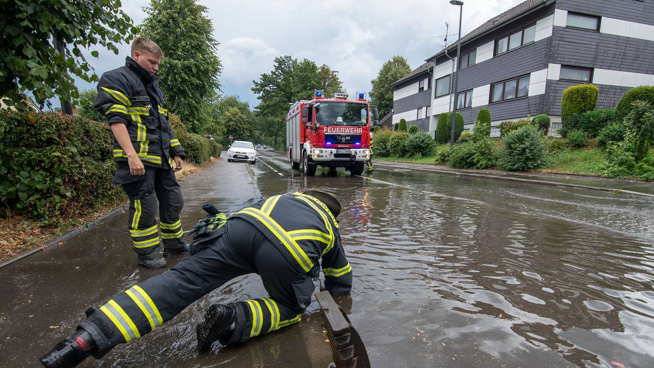 Nach dem Bilderbuchwochenende warnt der Deutsche Wetterdienst vor einem Wetter-Umschwung. Starkregen und Überflutungen sind möglich. Dasundatierte Symbolbild aus NRW zeigt Feuerwehrleute nach Starkregen an einer überfluteten Straße.