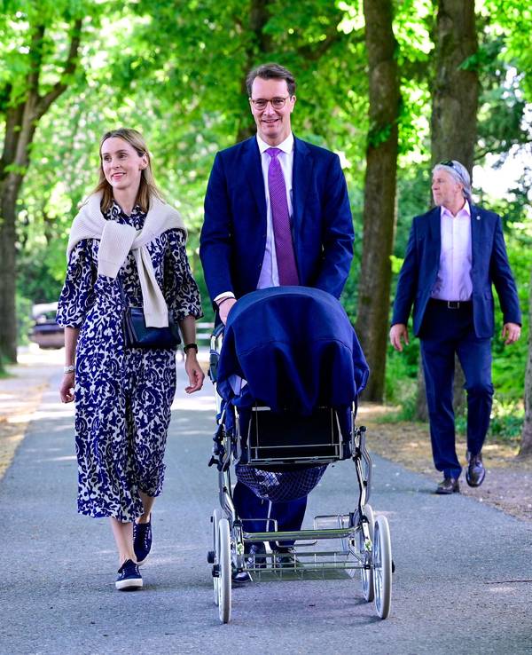 Hendrik Wüst spaziert mit seiner Familie durch einen Park.