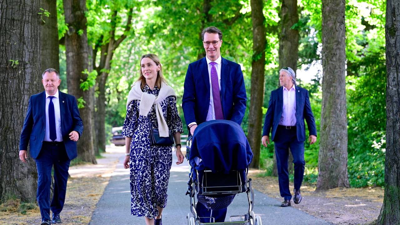 Hendrik Wüst spaziert mit seiner Familie durch einen Park.