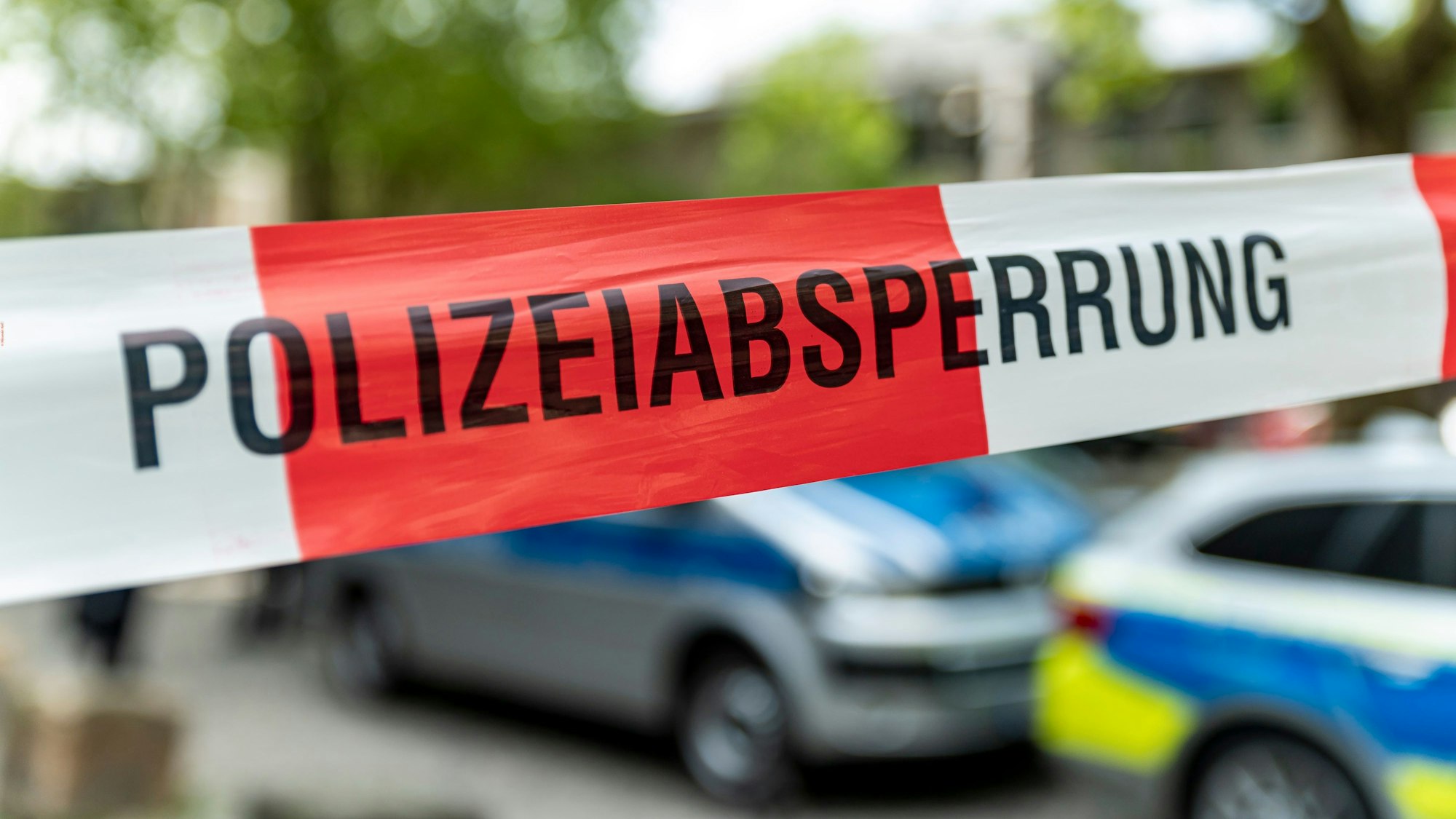 Absperrung der Kölner Polizei, dahinter Polizei-Autos.