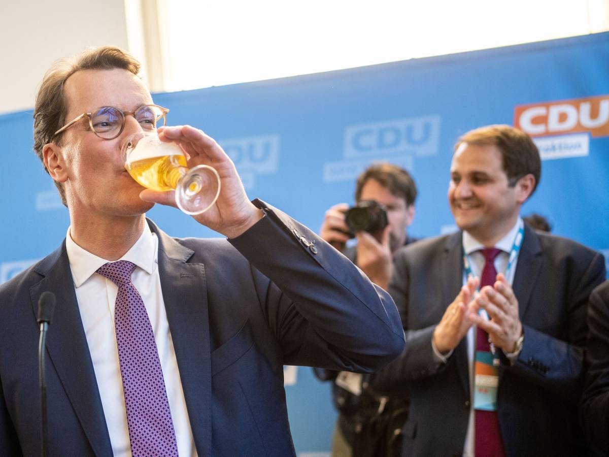 Hendrik Wüst nimmt in Düsseldorf auf seiner Wahlparty ein Schluck von einem Bier.
