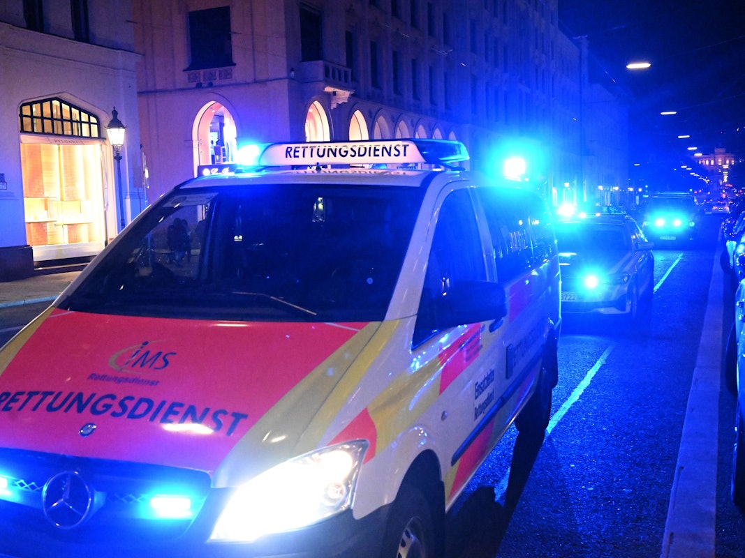 Ein Rettungswagen steht mit Blaulicht in der Maximilianstraße in München.