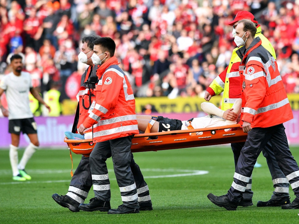 Florian Wirtz wird beim Spiel Bayer Leverkusen gegen den 1. FC Köln verletzt auf einer Trage vom Platz getragen.