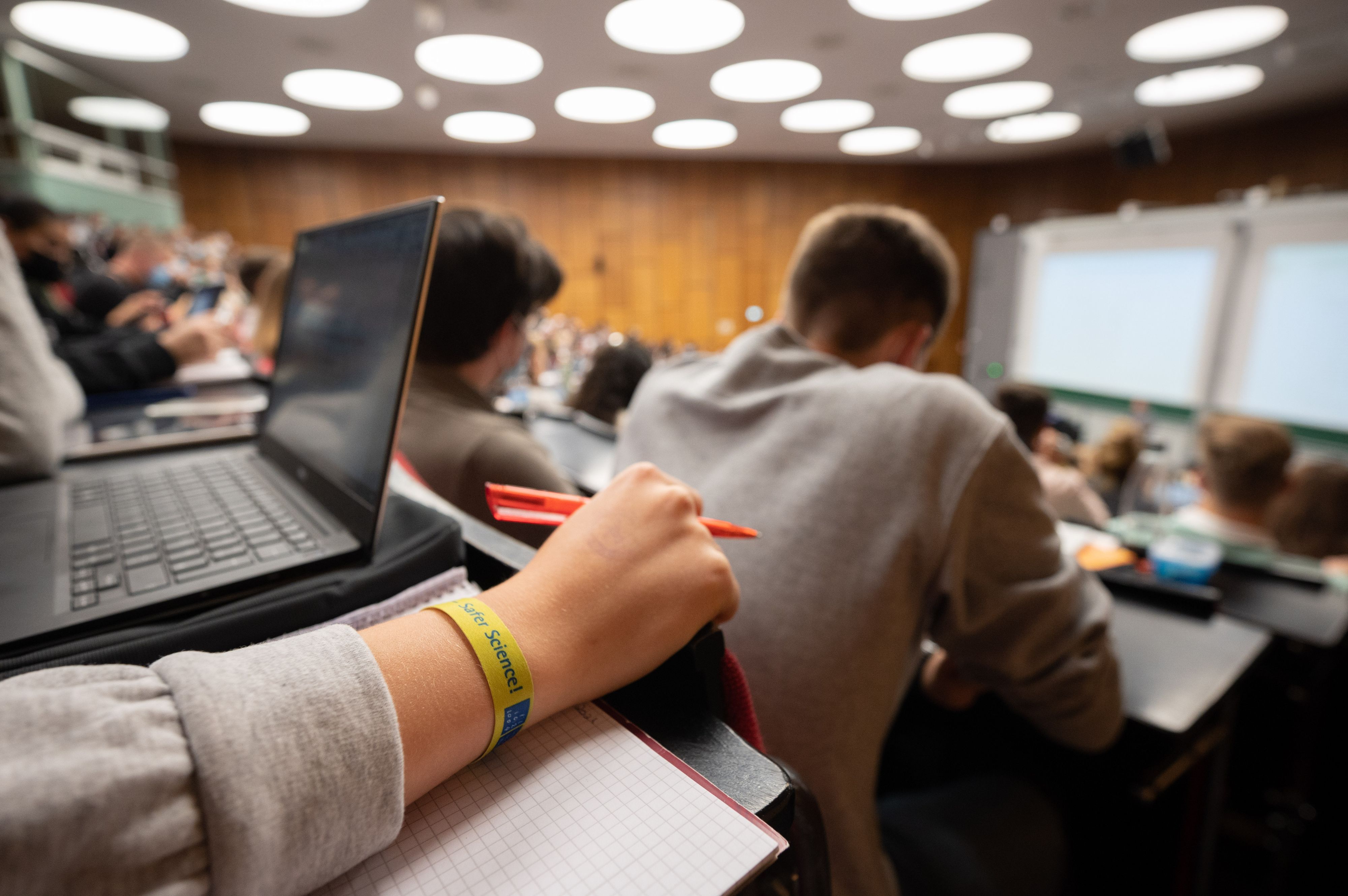 Eine Studentin sitzt mit weiteren Kommilitonen und Kommilitoninnen am 18. Oktober 2021 in einem Hörsaal.