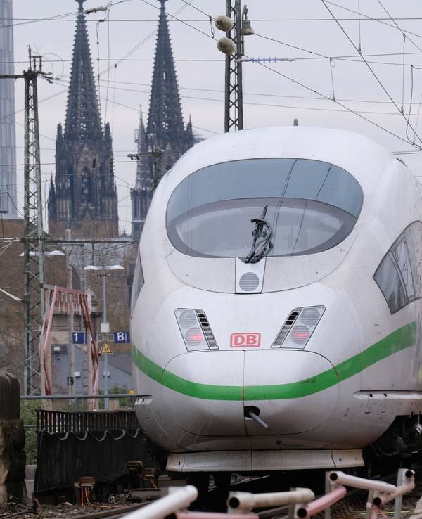 Ein weiß-grüner ICE am 16. April 2021 vor dem Kölner Dom.