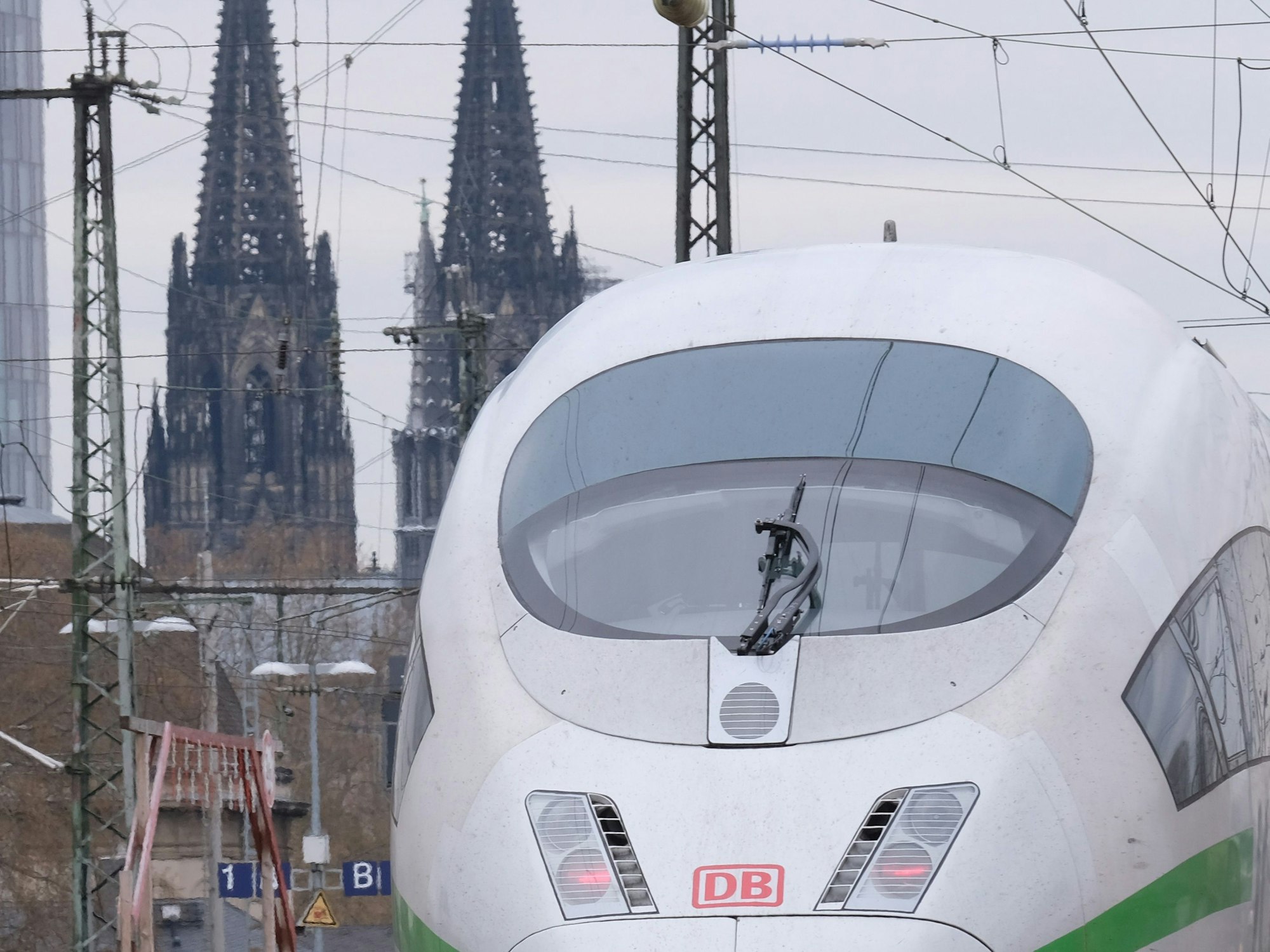 Ein weiß-grüner ICE am 16. April 2021 vor dem Kölner Dom.