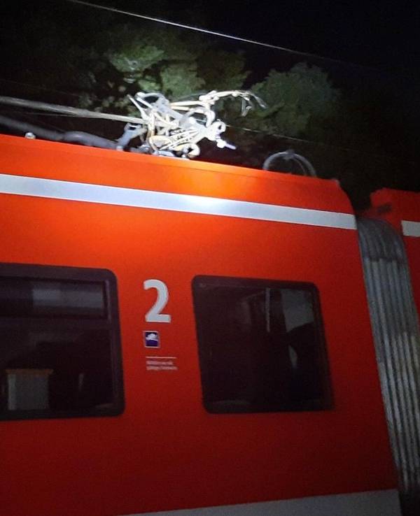 Kaputtes Fahrrad hängt in der Oberleitung eines Zugs.