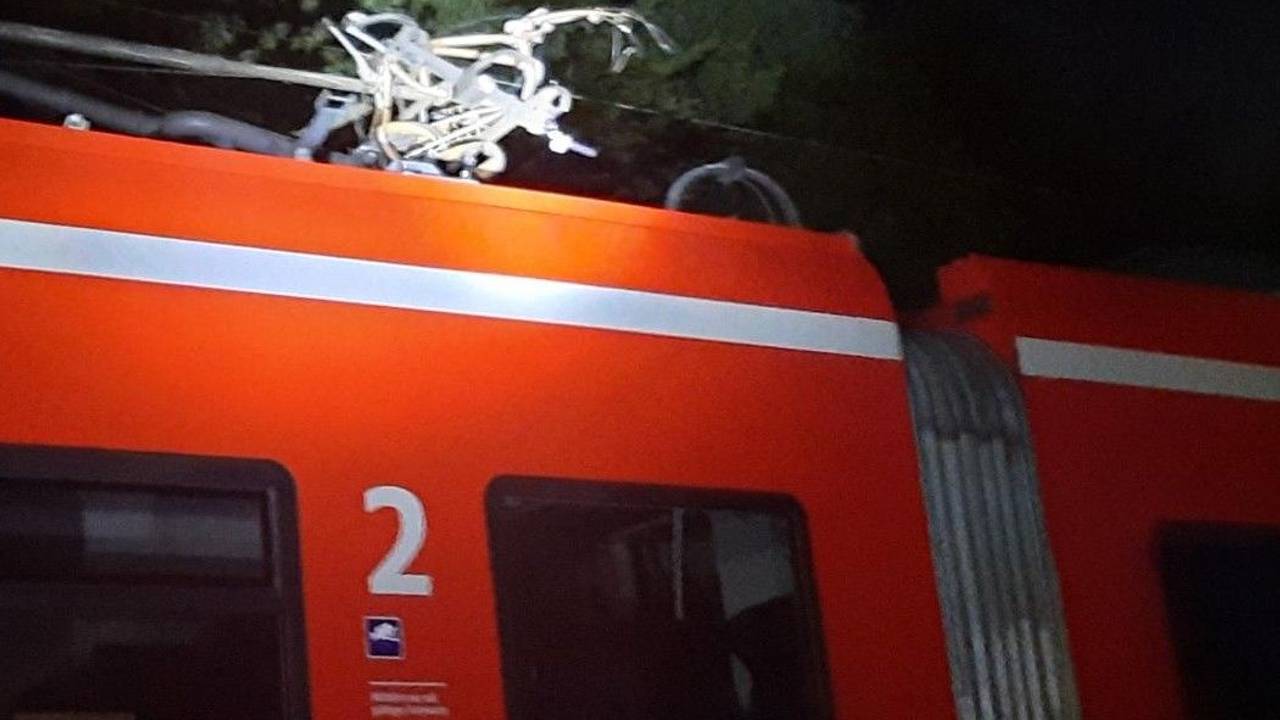 Kaputtes Fahrrad hängt in der Oberleitung eines Zugs.
