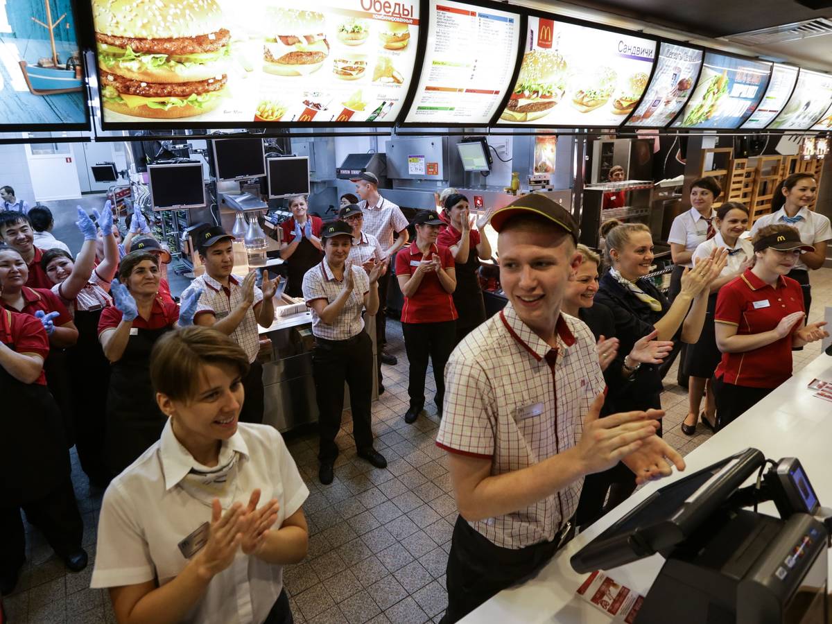 Mitarbeiter des Fast-Food-Restaurants McDonald's auf dem Puschkin-Platz in Moskau applaudieren 2014, weil ihre Filiale damals wiedereröffnet worden ist.