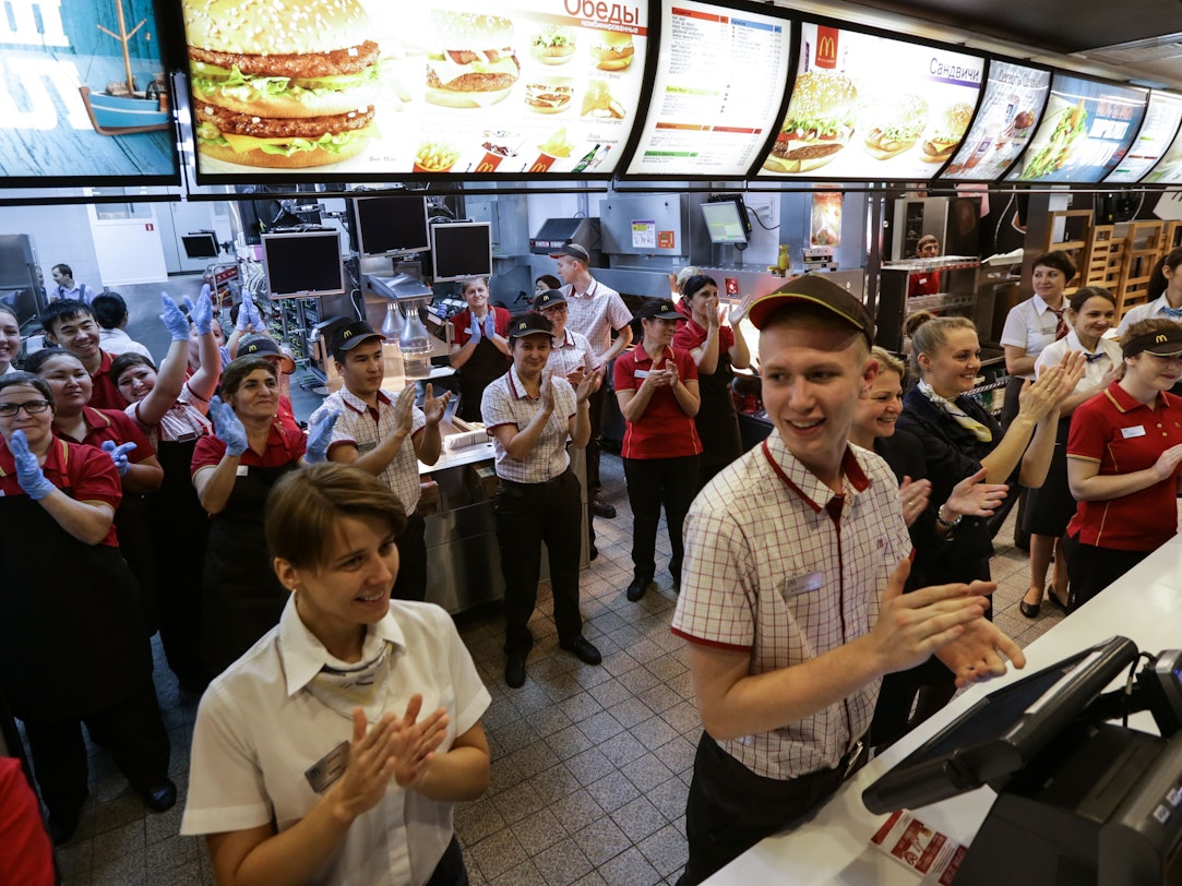 Mitarbeiter des Fast-Food-Restaurants McDonald's auf dem Puschkin-Platz in Moskau applaudieren 2014, weil ihre Filiale damals wiedereröffnet worden ist.
