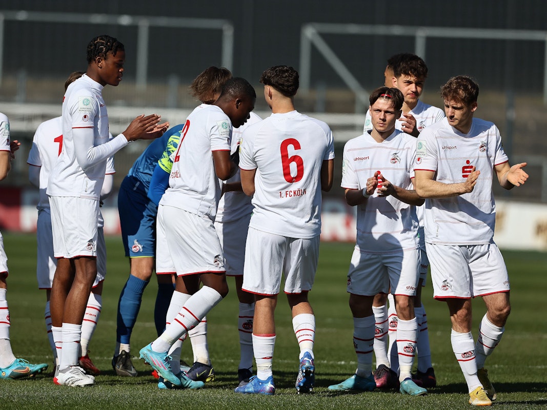 Die Spieler der U19 des 1. FC Köln klatschen sich in einem Spiel ab.