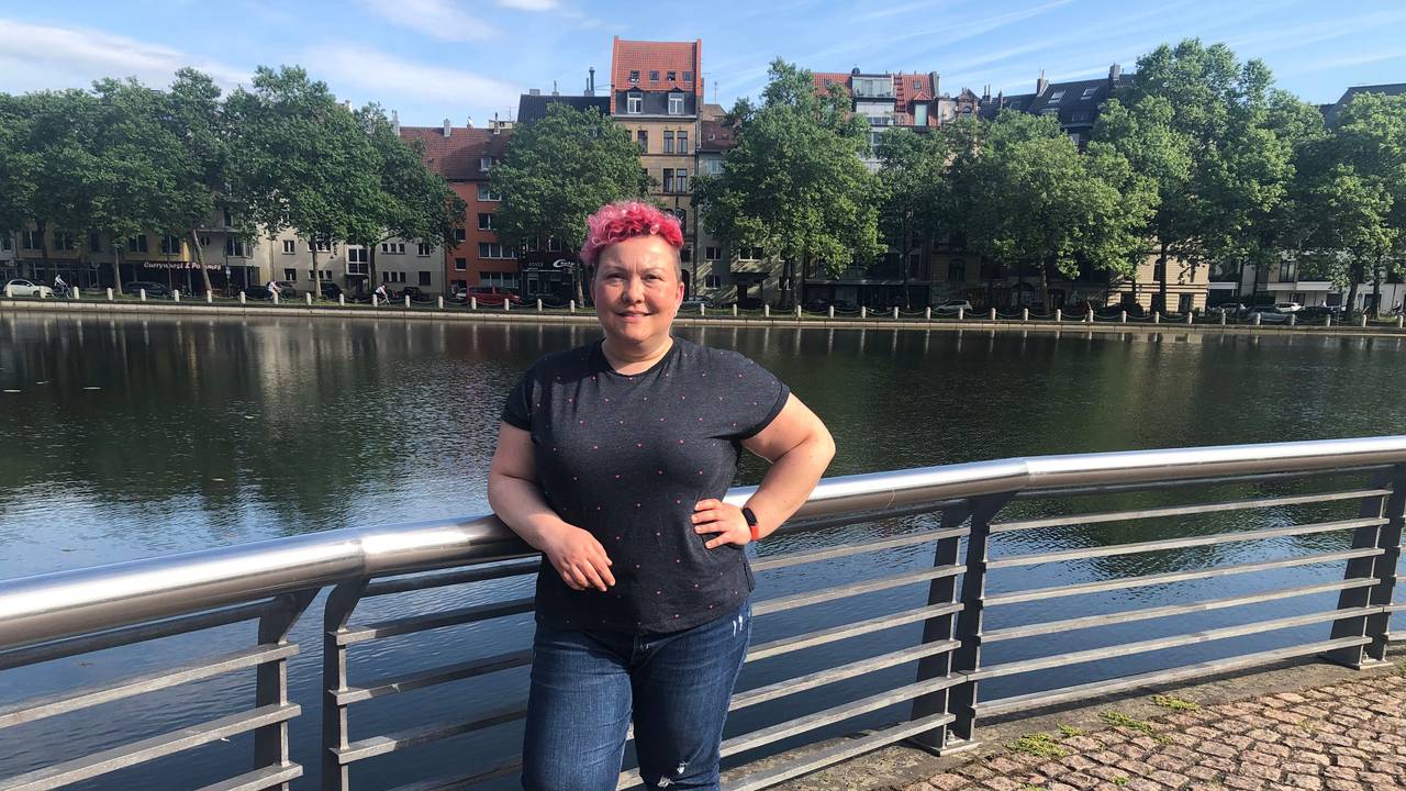 Stadtführerin Jackie Kutz steht an einem Weiher in Köln.