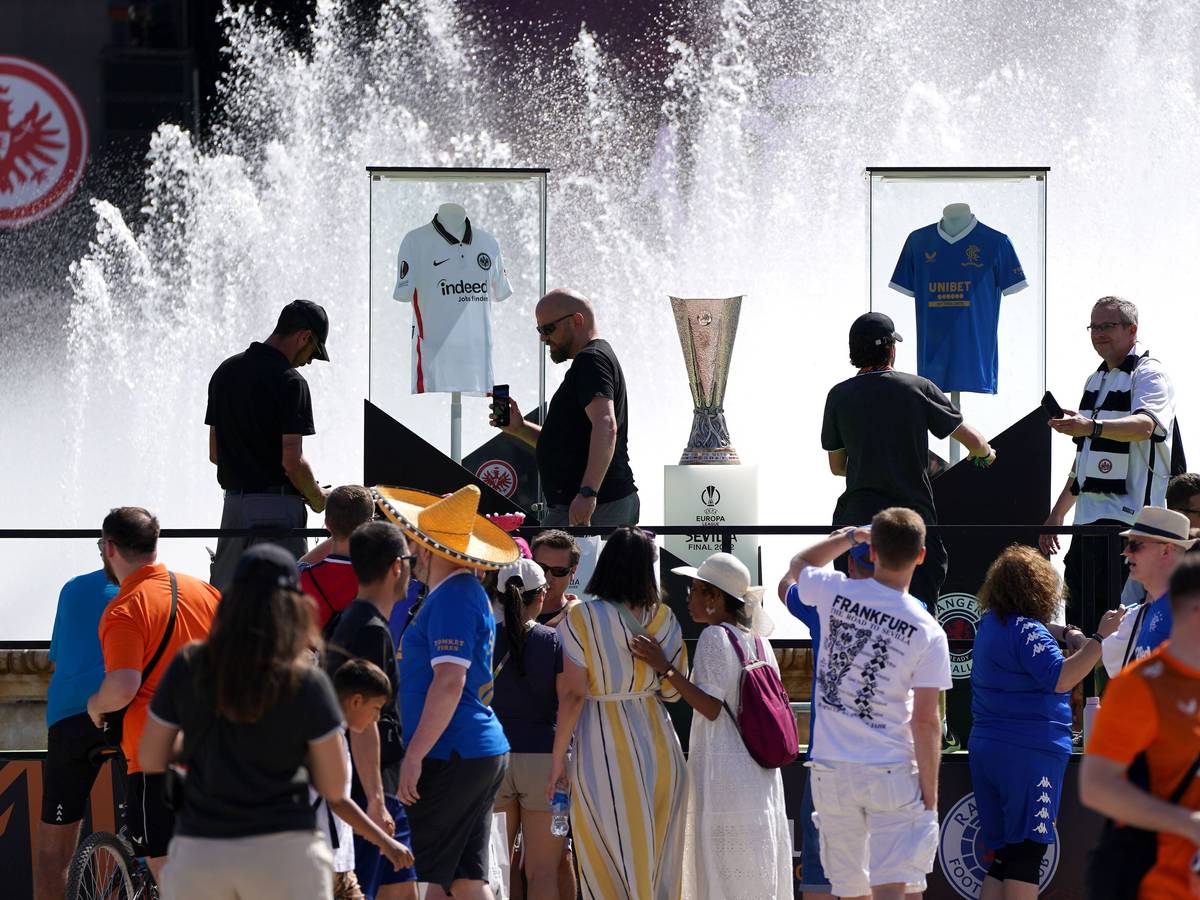 Der Pokal der Europa League neben den Trikots von Eintracht Frankfurt und den Glasgow Rangers an der Plaza de España in Sevilla.