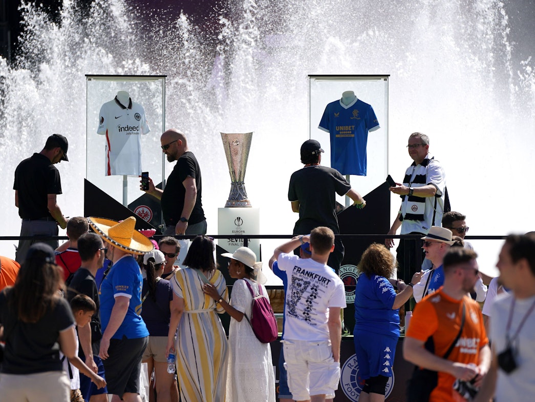 Der Pokal der Europa League neben den Trikots von Eintracht Frankfurt und den Glasgow Rangers an der Plaza de España in Sevilla.