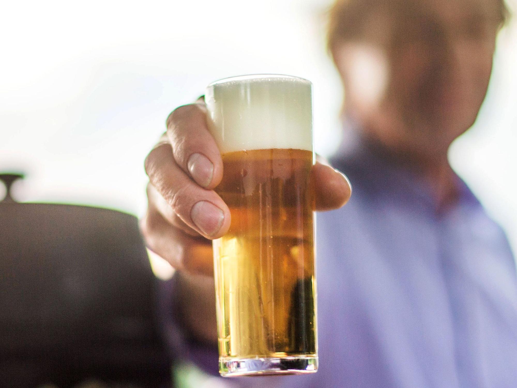Ein frisch gezapftes Kölsch wird auf einer Party in die Kamera gehalten.