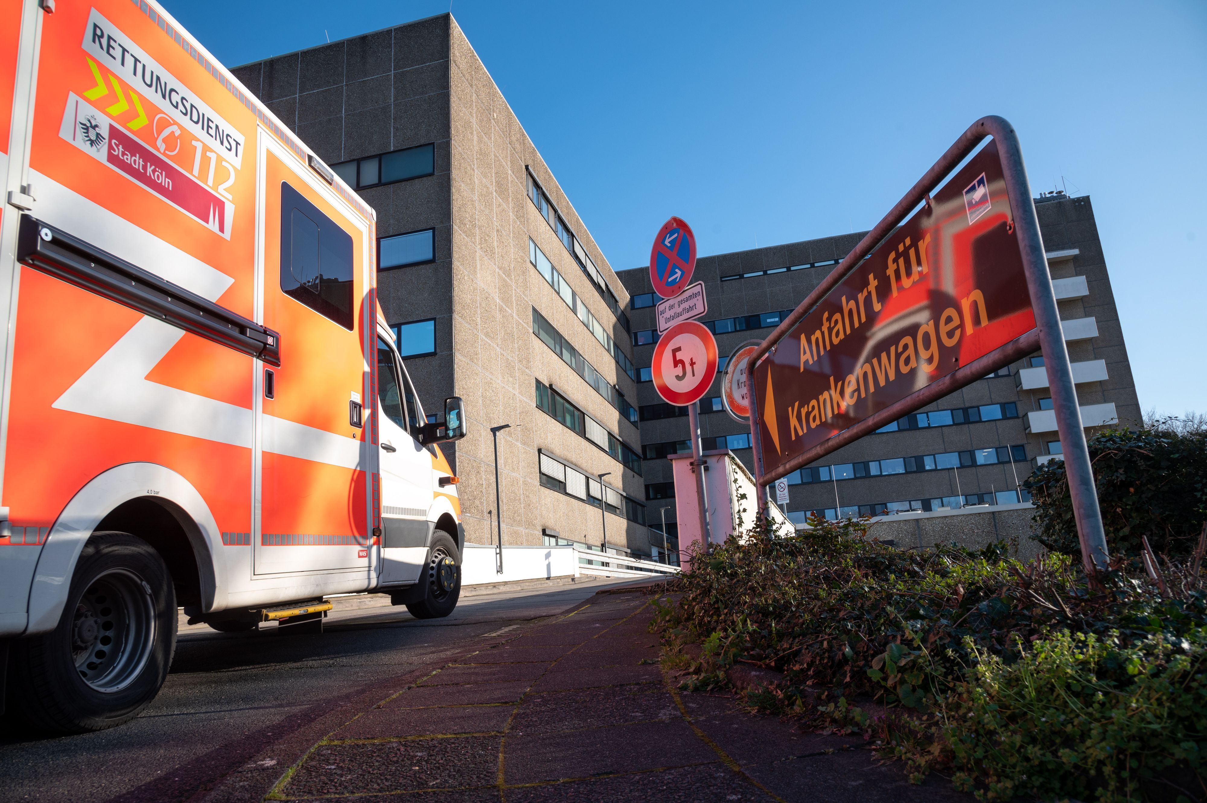 Ein orange-weißer Krankenwagen fährt in die Porzer Krankenhaus-Einfahrt ein.