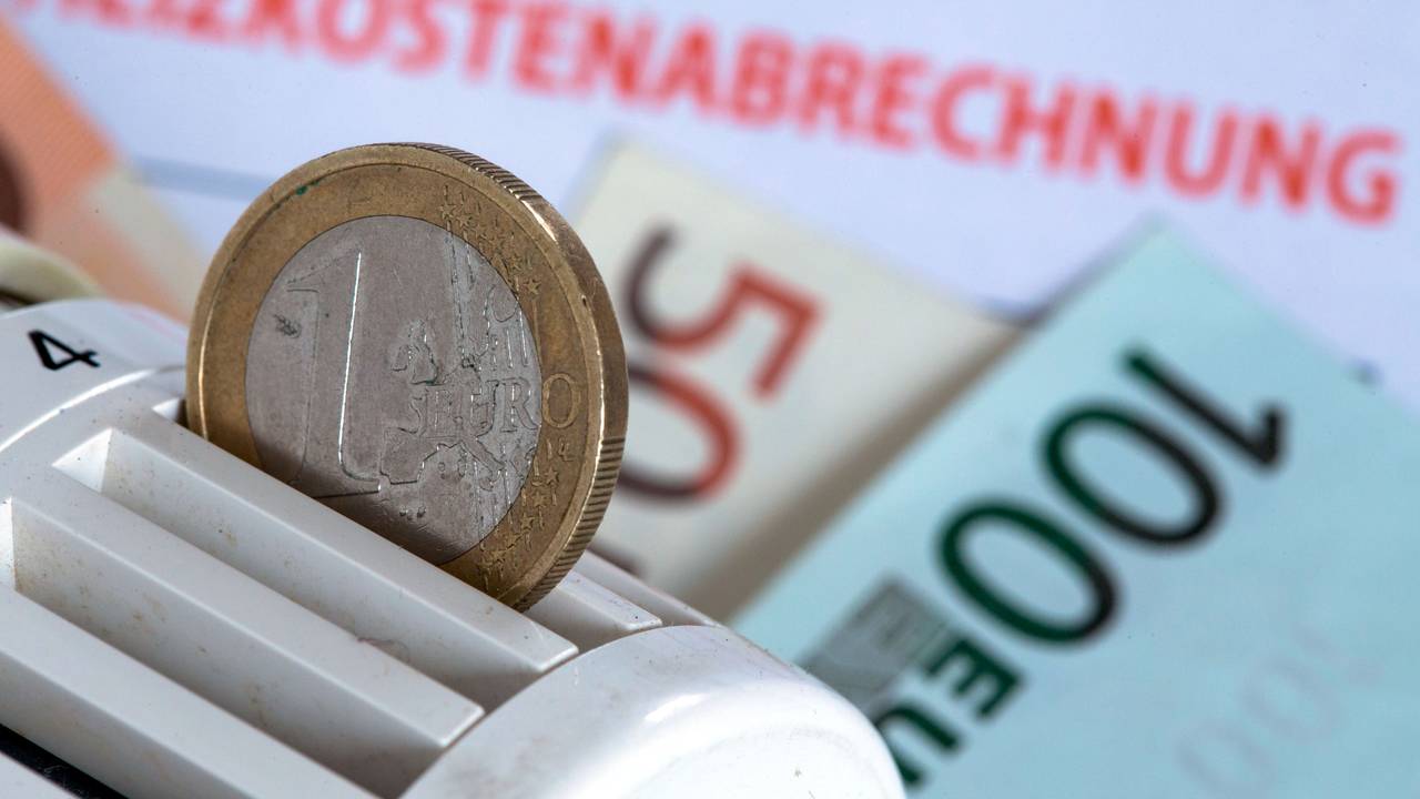 Eine Euromünze steckt am 04. Dezember 2014 in einem Heizungsthermostat, der auf einer Heizkostenabrechnung und Euro-Geldscheinen liegt.