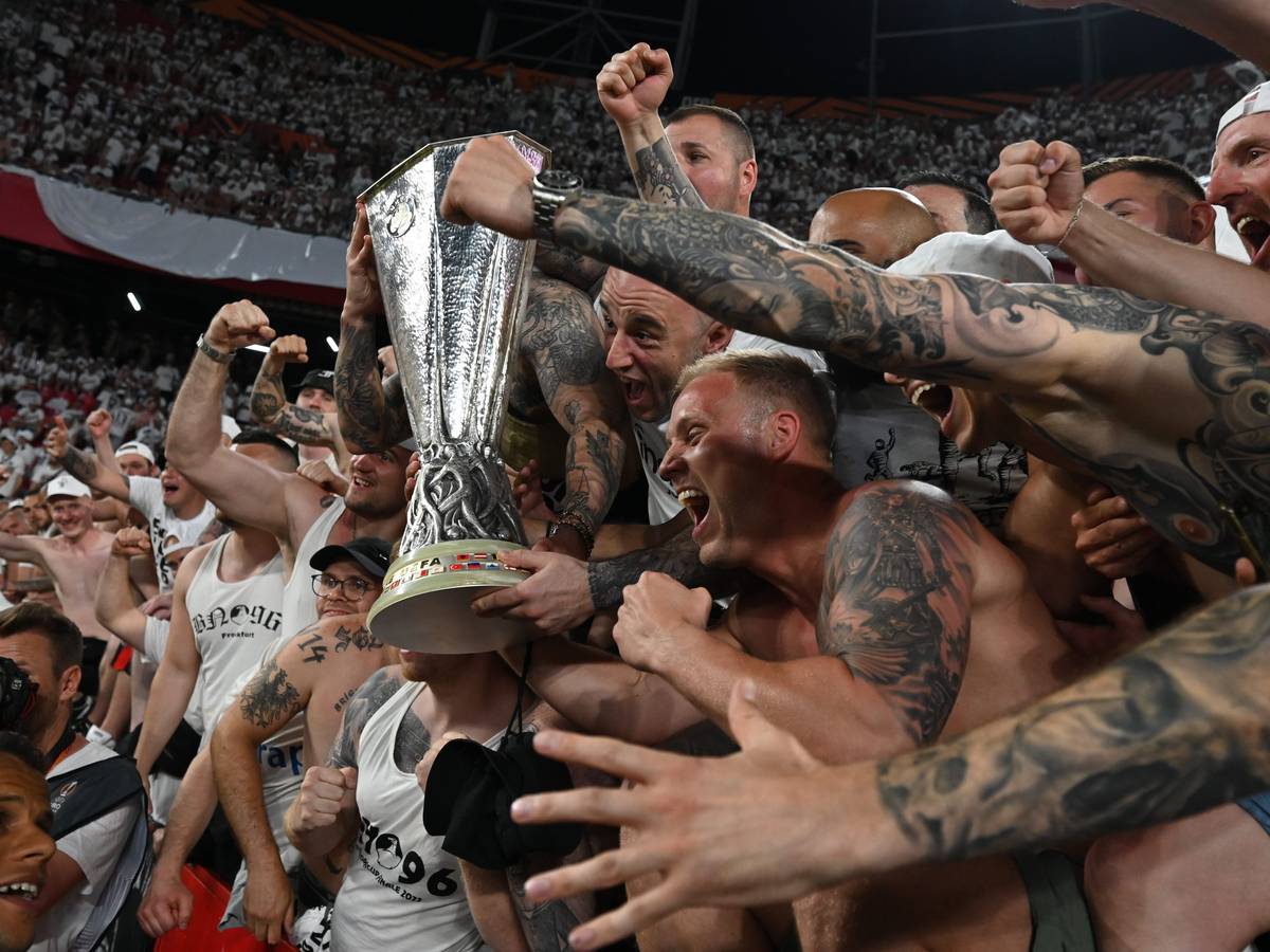 Eintracht Frankfurts Fans feiern mit dem Pokal.