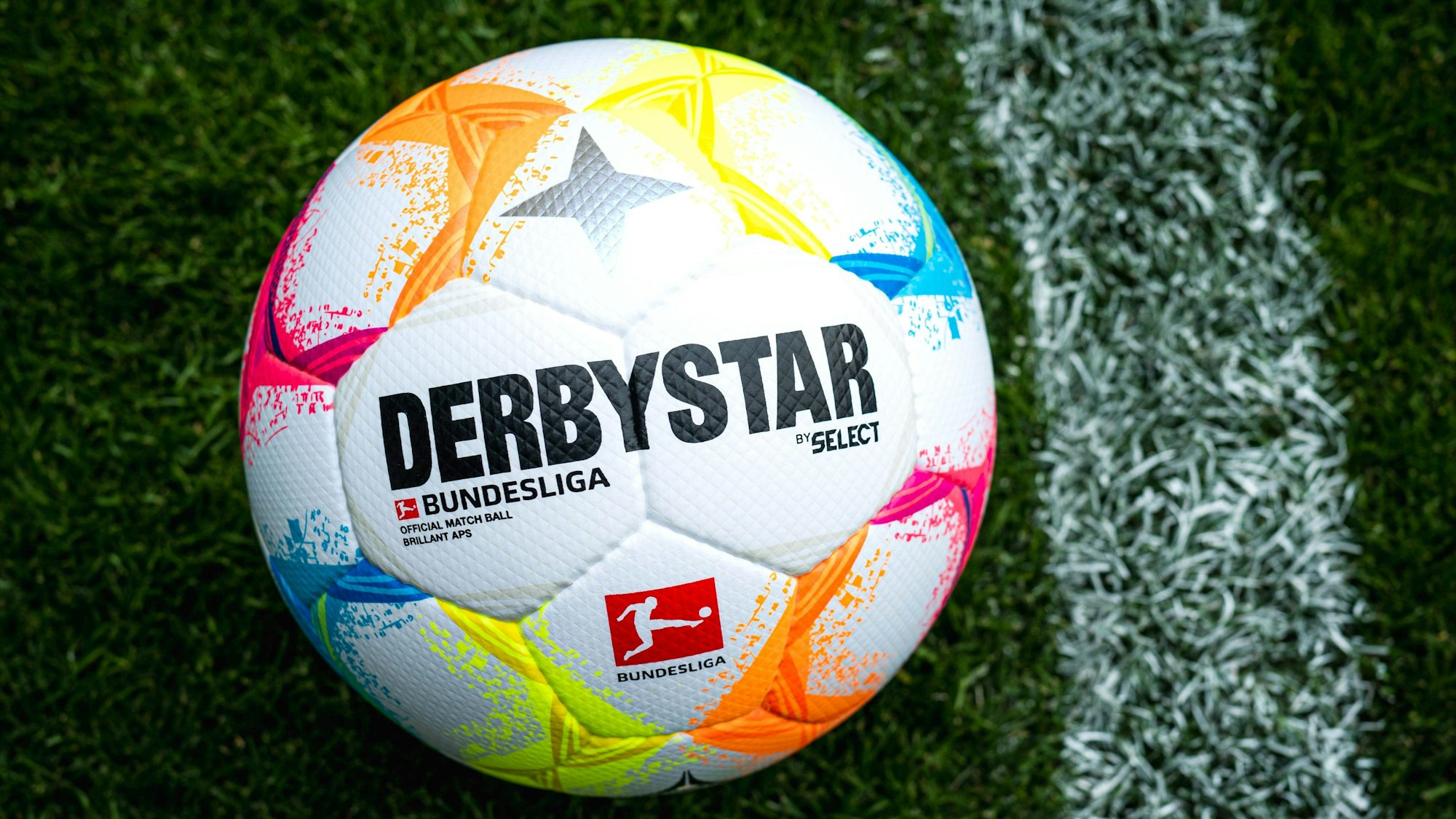 Der neue Bundesliga-Spielball mit vielen farblichen Details liegt auf Fußball-Rasen