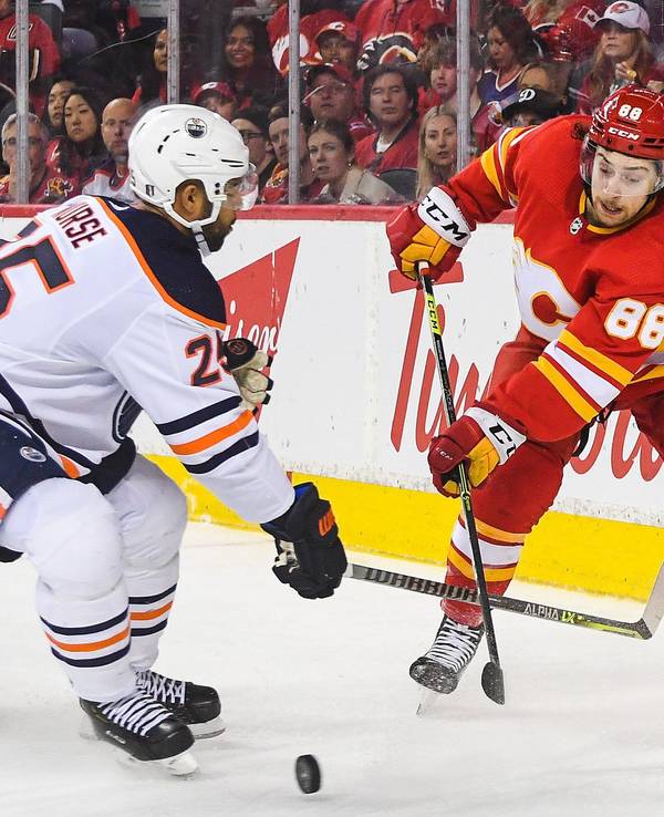 Andrew Mangiapane von den Calgary Flames kämpf mit Darnell Nurse von den Edmonton Oilers auf dem Eis um den Puck.