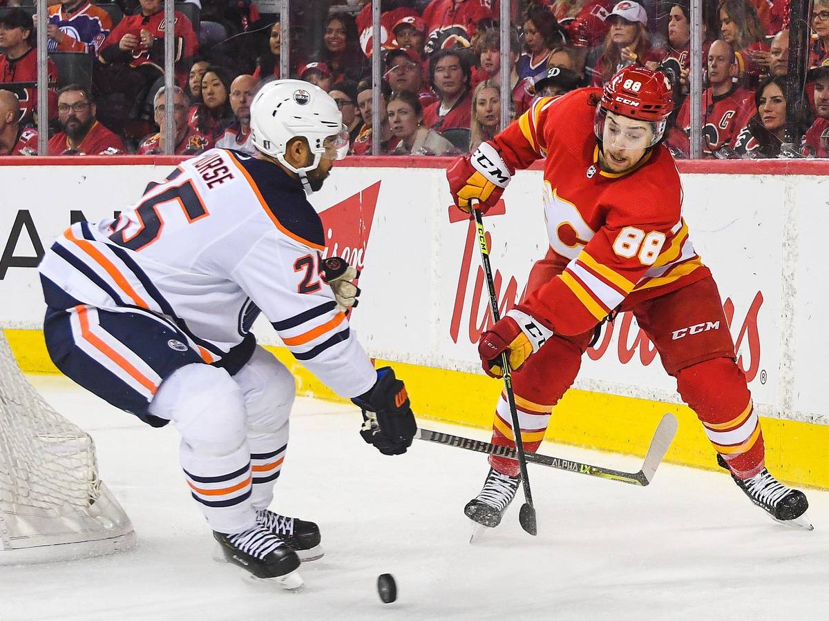 Andrew Mangiapane von den Calgary Flames kämpf mit Darnell Nurse von den Edmonton Oilers auf dem Eis um den Puck.