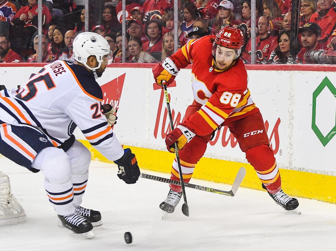 Andrew Mangiapane von den Calgary Flames kämpf mit Darnell Nurse von den Edmonton Oilers auf dem Eis um den Puck.