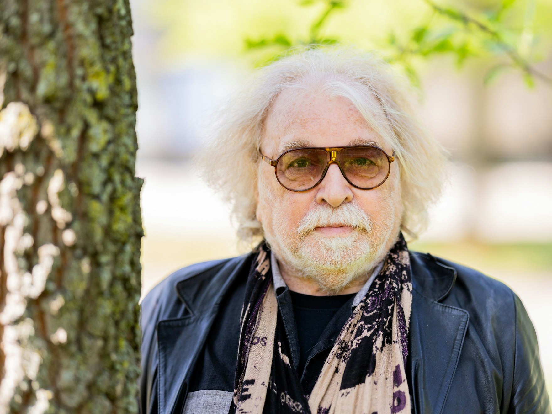 Roncalli-Chef Bernhard Paul guckt neben einem Baum in die Kamera.