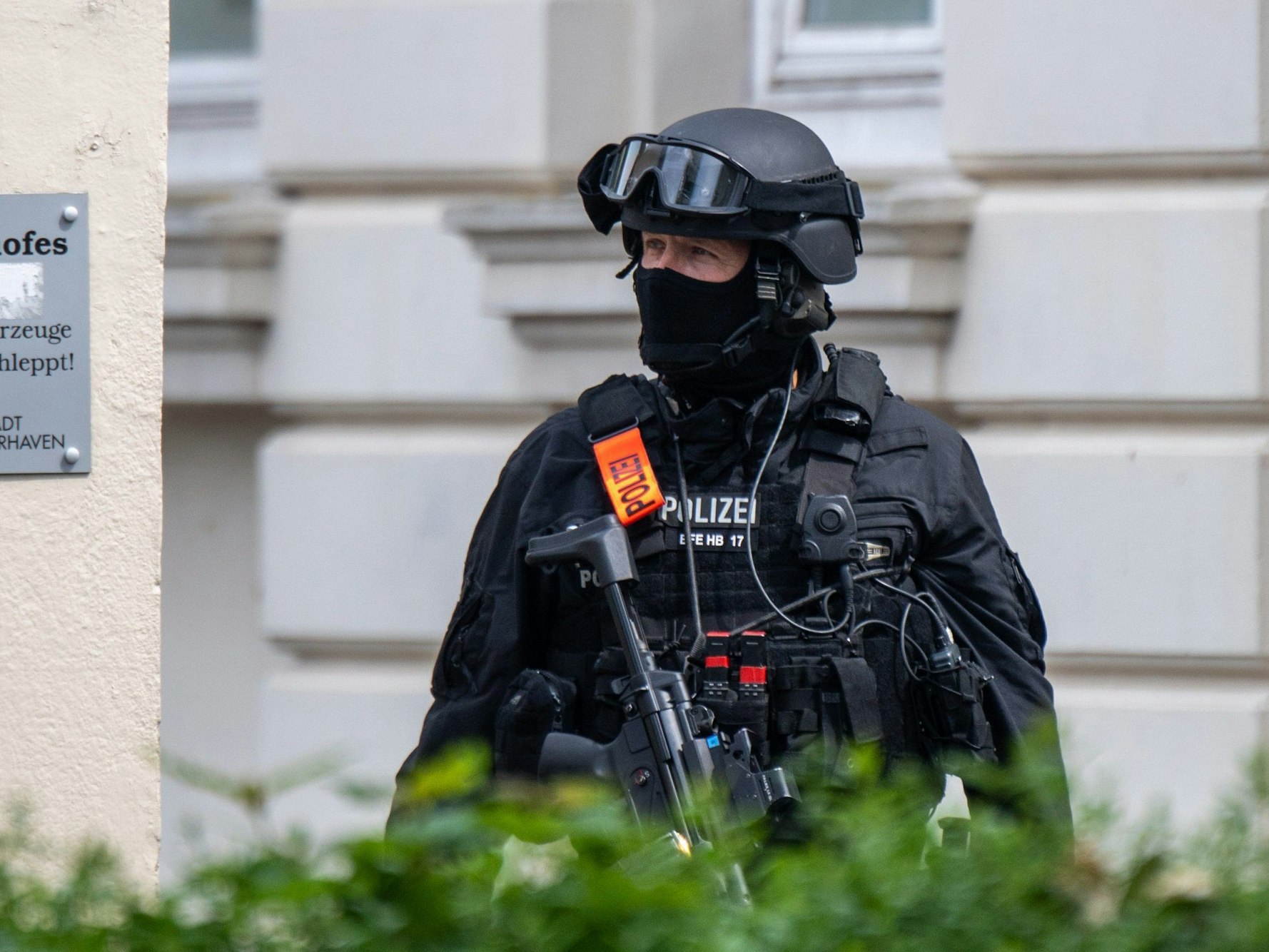 19.05.2022, Bremen, Bremerhaven: Eine Sondereinsatzkraft der Polizei ist vor der Schule im Einsatz. An einem Gymnasium in Bremerhaven ist am Donnerstagvormittag geschossen worden. Eine Frau sei mit der Waffe verletzt worden, sagte eine Polizeisprecherin. Der Täter wurde nach der Tat festgenommen. Foto: Sina Schuldt/dpa +++ dpa-Bildfunk +++