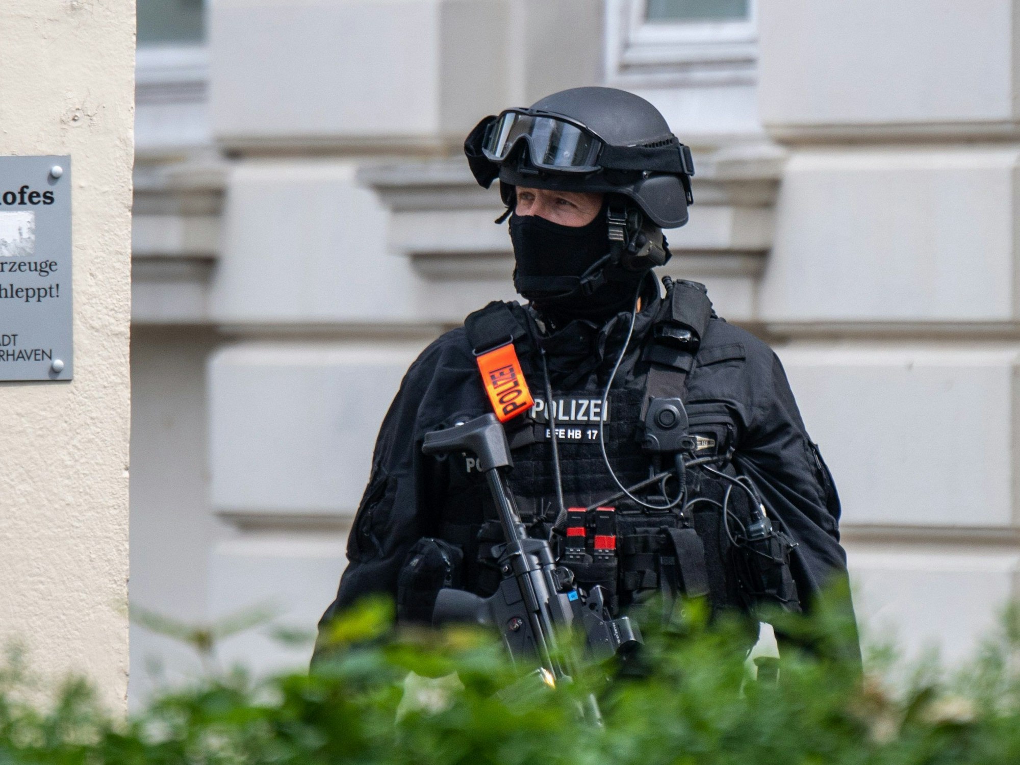 19.05.2022, Bremen, Bremerhaven: Eine Sondereinsatzkraft der Polizei ist vor der Schule im Einsatz. An einem Gymnasium in Bremerhaven ist am Donnerstagvormittag geschossen worden. Eine Frau sei mit der Waffe verletzt worden, sagte eine Polizeisprecherin. Der Täter wurde nach der Tat festgenommen. Foto: Sina Schuldt/dpa +++ dpa-Bildfunk +++