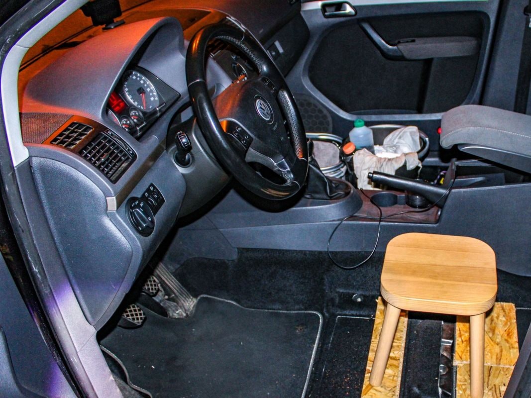 Ein Holzsschemel als Fahrersitz in einem Auto