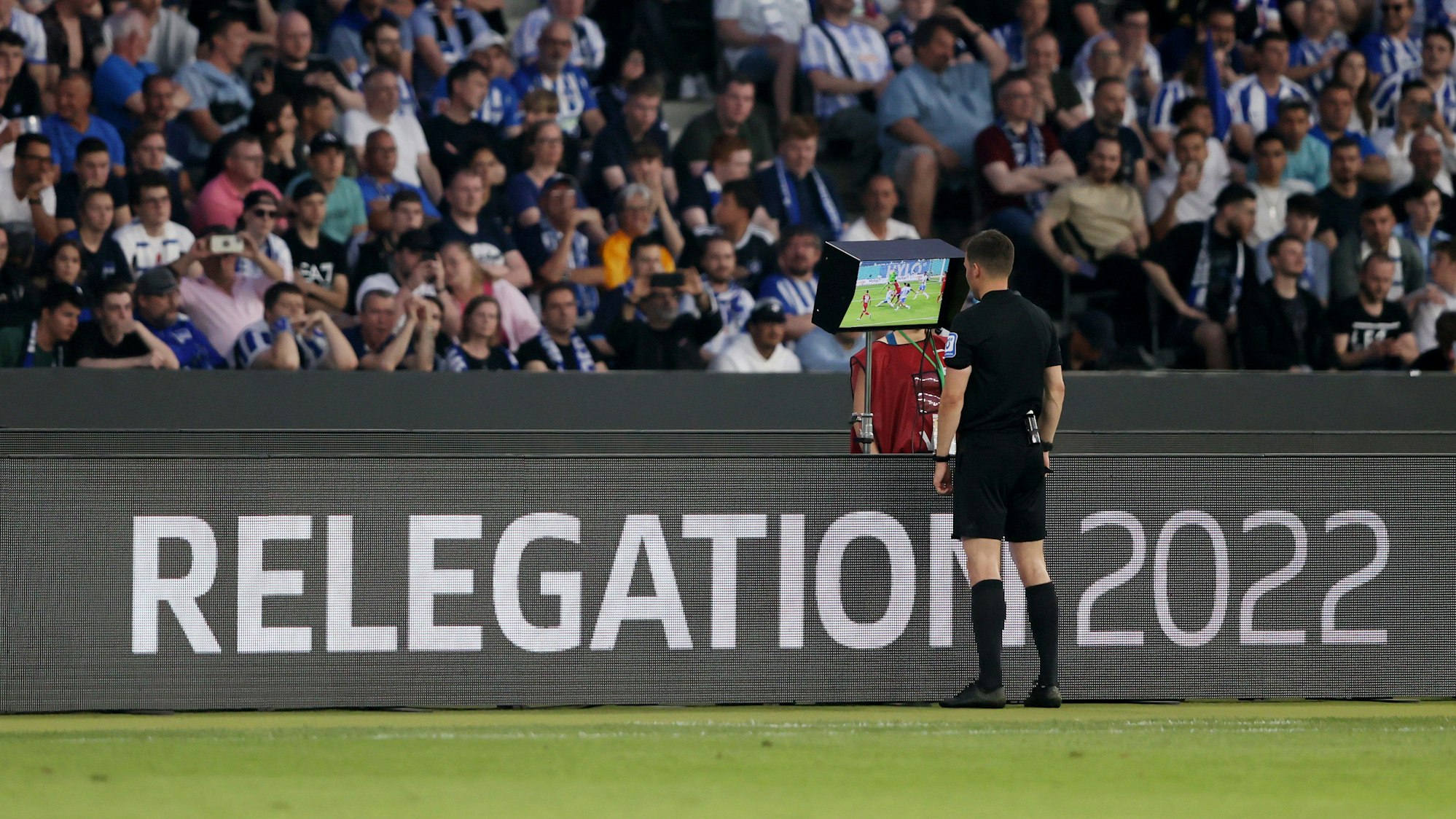 Schiri Harm Osmers schaut sich im Relegations-Hinspiel eine mögliche Elfmeter-Szene für den Hamburger SV bei Hertha BSC an.