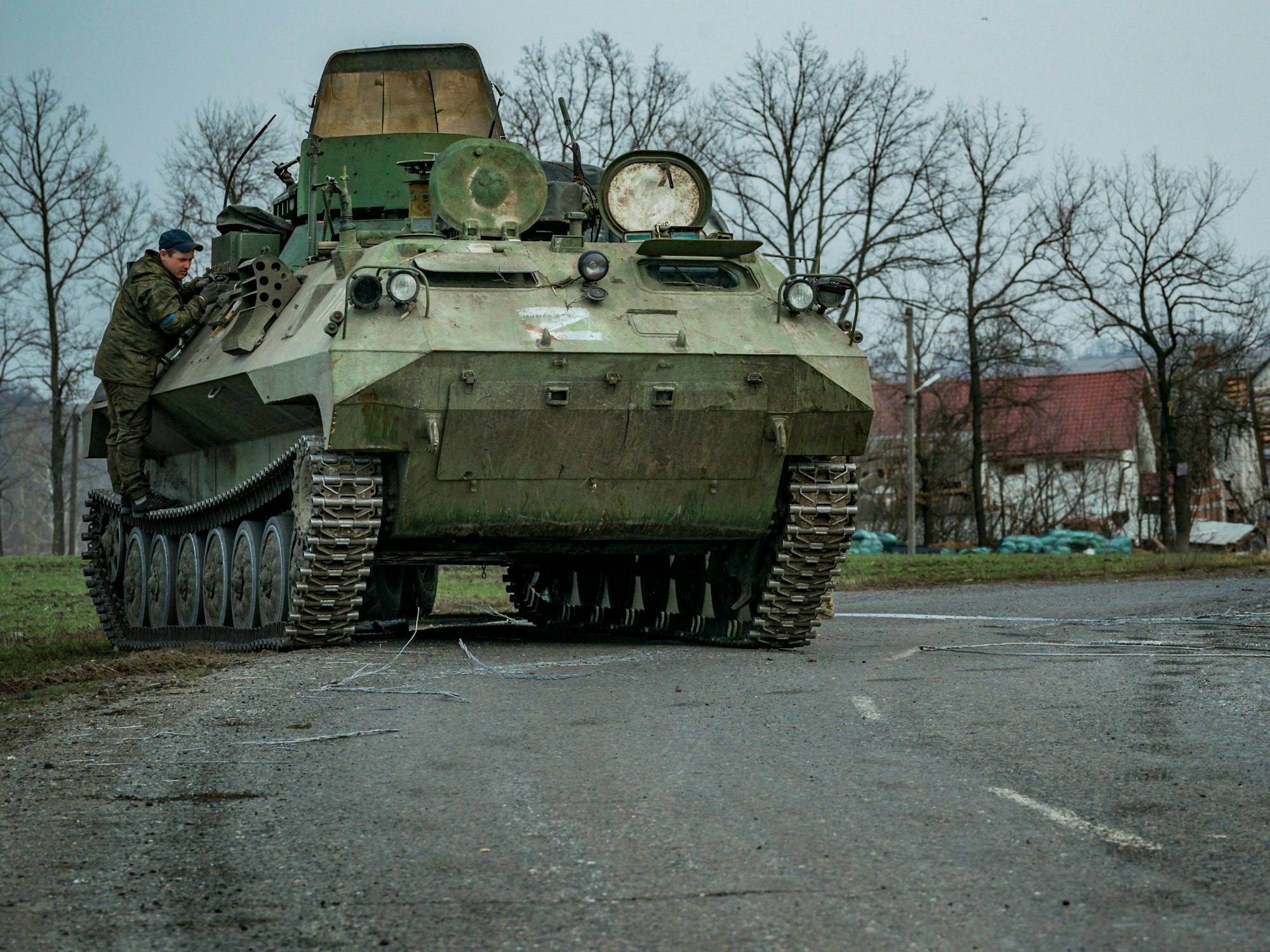 Ein ukrainischer Soldat repariert ein erbeutetes gepanzertes Fahrzeug der russischen Armee mit dem Symbol Z.