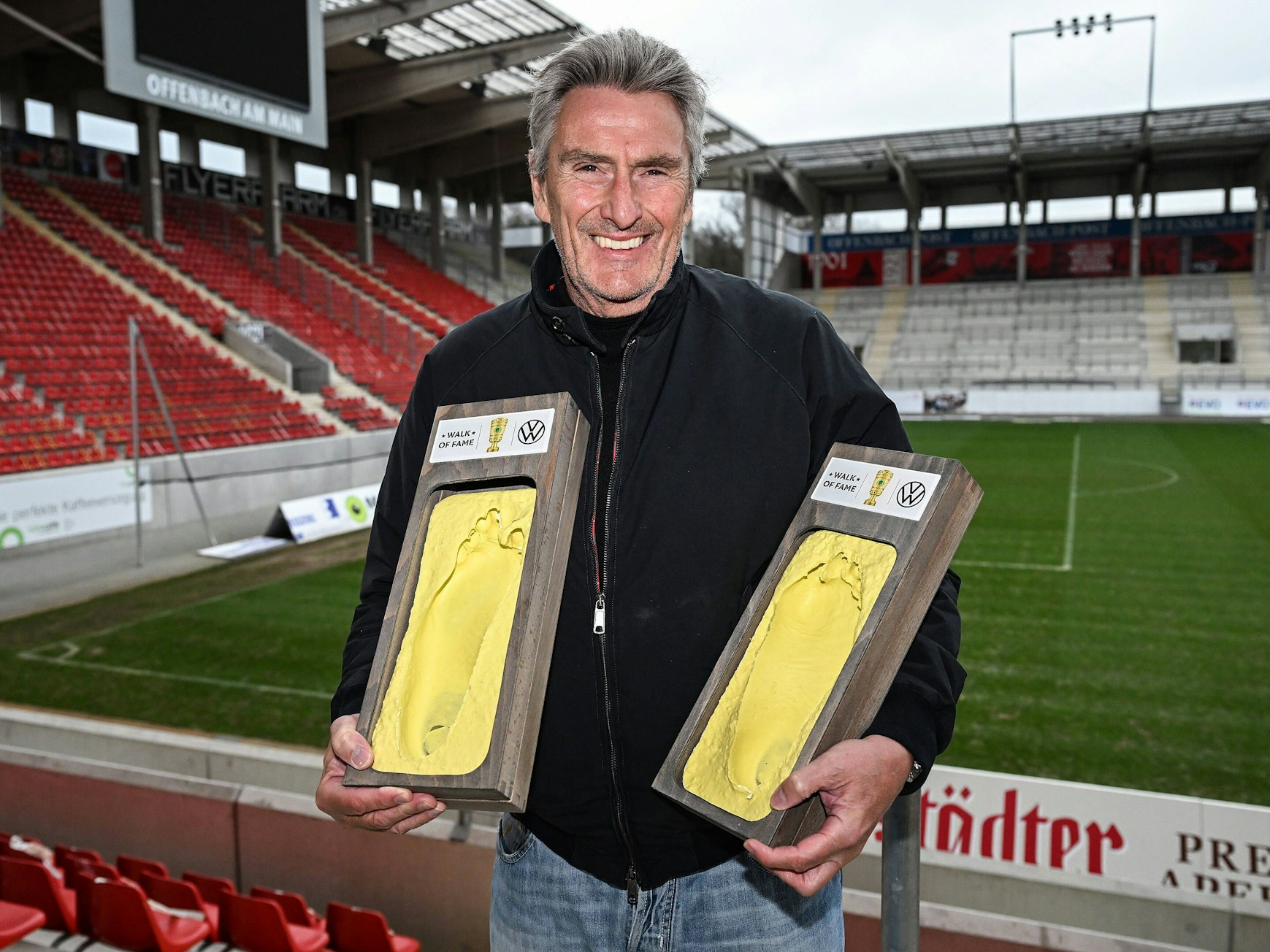 Dieter Müller hält zwei Abdrücke seiner Füße in der Hand.