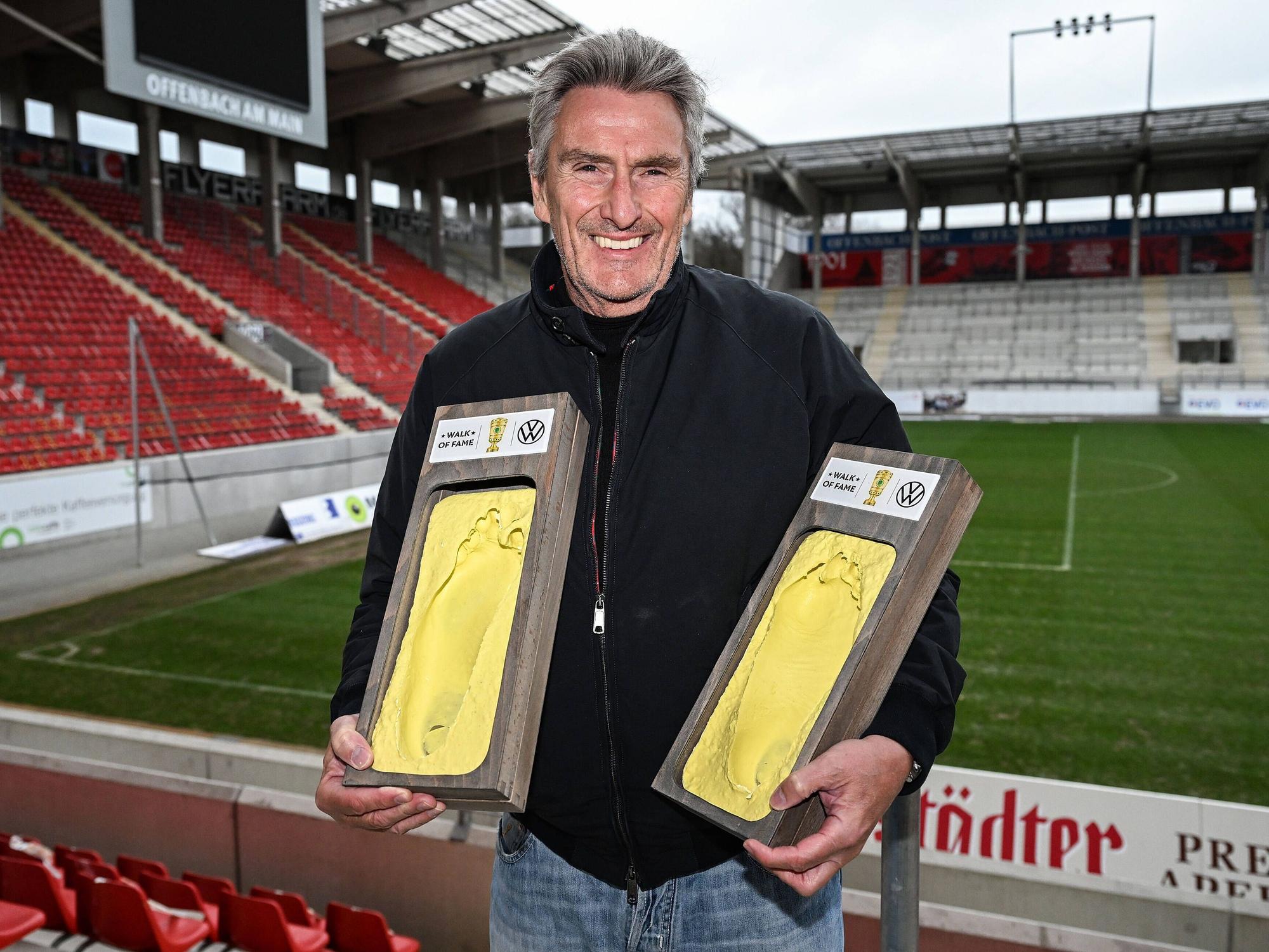 Dieter Müller hält zwei Abdrücke seiner Füße in der Hand.