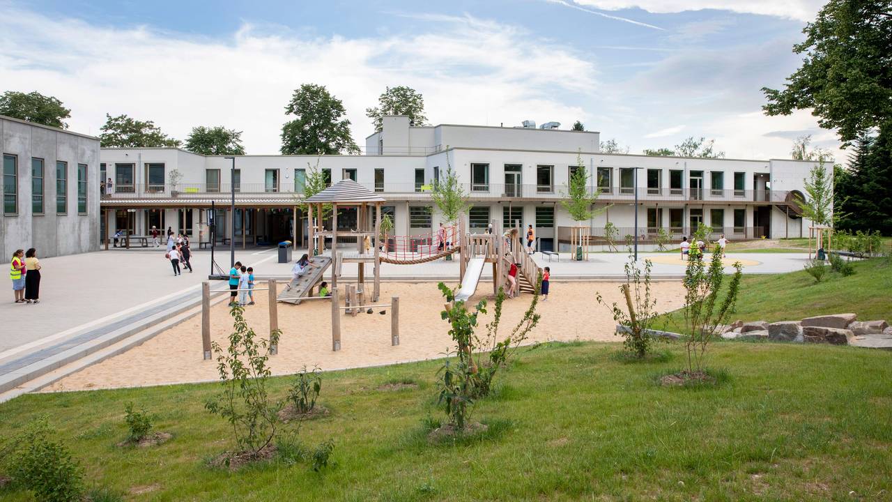 Auf dem Spielplatz vor der Friedrich-List-Schule in Köln-Porz spielen und klettern Kinder.