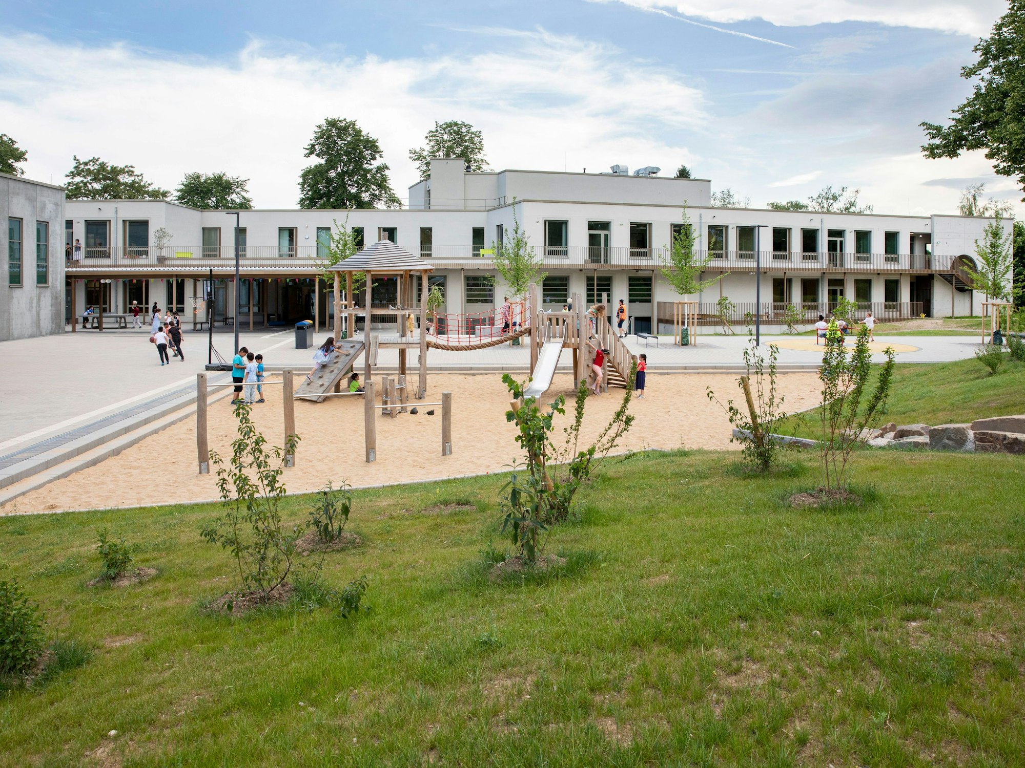 Auf dem Spielplatz vor der Friedrich-List-Schule in Köln-Porz spielen und klettern Kinder.