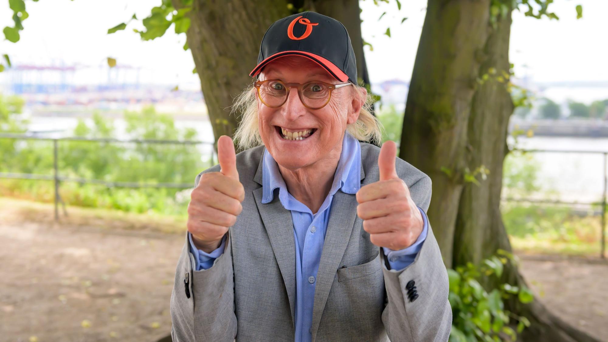Otto Waalkes zeigt beide Daumen nach oben und lächelt für ein Foto.
