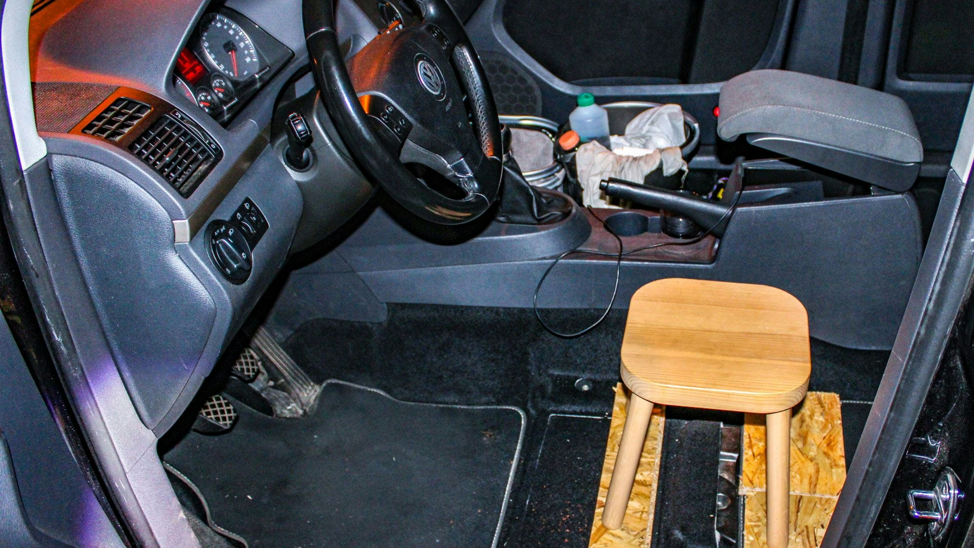 Statt eines Fahrersitzes steht in einem Auto an der Stelle ein Holzschemel.