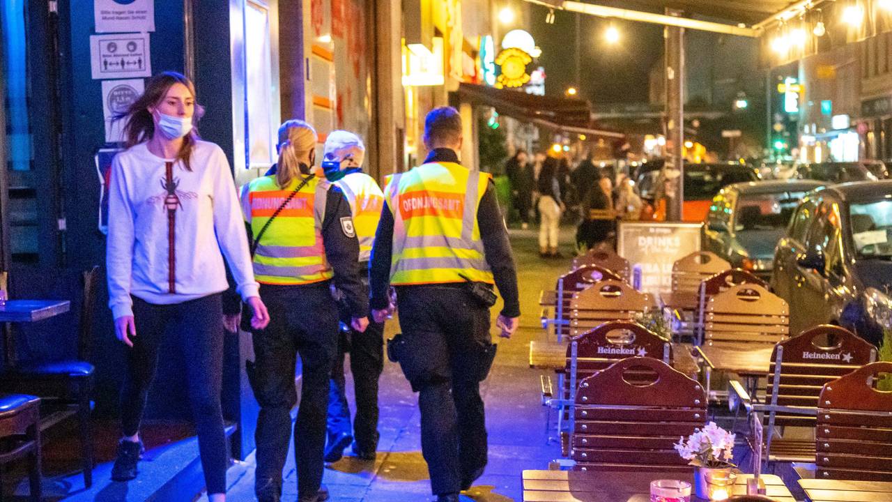 Mitarbeiter des Ordnungsamtes laufen über die Zülpicher Straße in Köln.