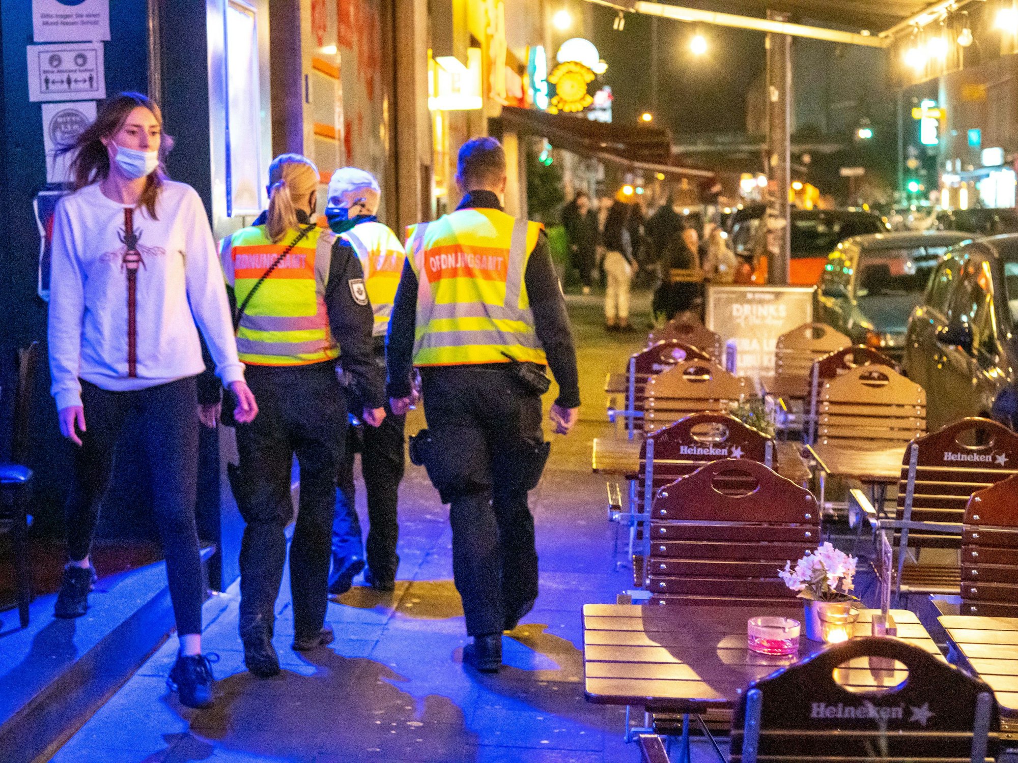 Mitarbeiter des Ordnungsamtes laufen über die Zülpicher Straße in Köln.